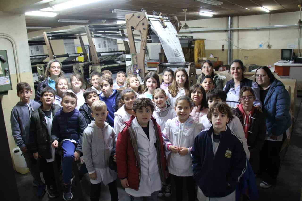 Una delegación de la Escuela 216 junto a la máquina impresora.