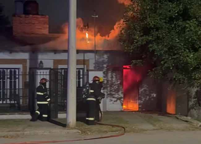 Bomberos Voluntarios trabajando en el garaje de la casa siniestrada.